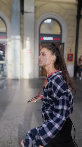 young woman walking through a train station