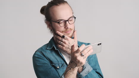 caucasian young man watching video on smartphone.