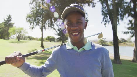 Video-of-happy-african-american-man-holding-golf-club-on-golf-filed