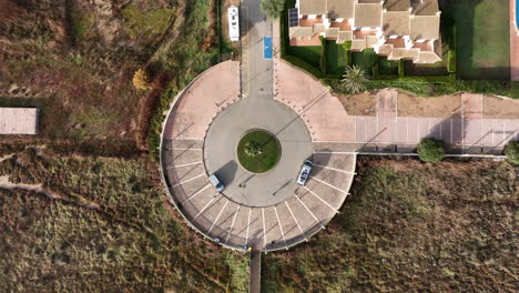 Roundabout-with-people-walking,-long-shadows-on-ground