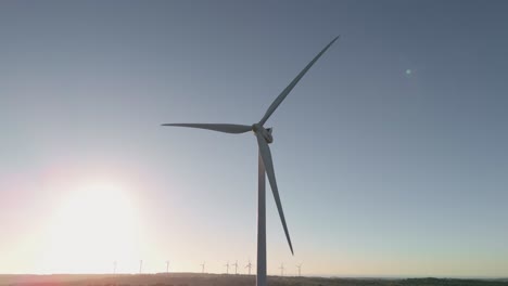 wind turbine spinning against sky at sunrise