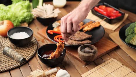 man dipping fried chicken in barbecue sauce medium shot