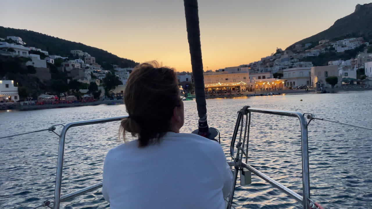 Navigazione al tramonto in Grecia: donna su yacht nel porto
