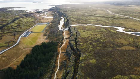 drone flying over a beautiful canyon in thingvellir national park in iceland on a sunny day