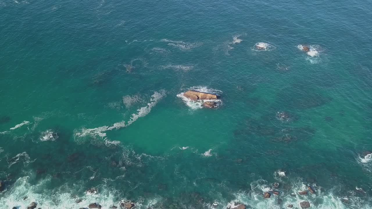 해안에 있는 바위 산 근처의 거품 파도의 공중, 해안선 근처