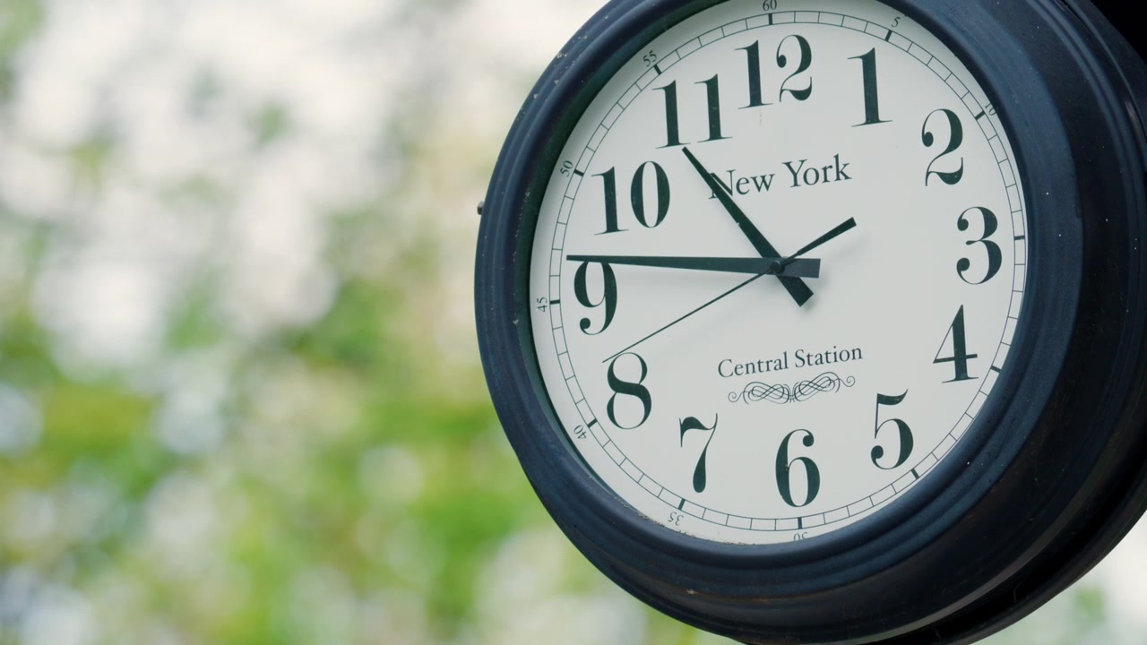 Classic outdoor clock with New York inscription, captured in soft daylight with a blurred background