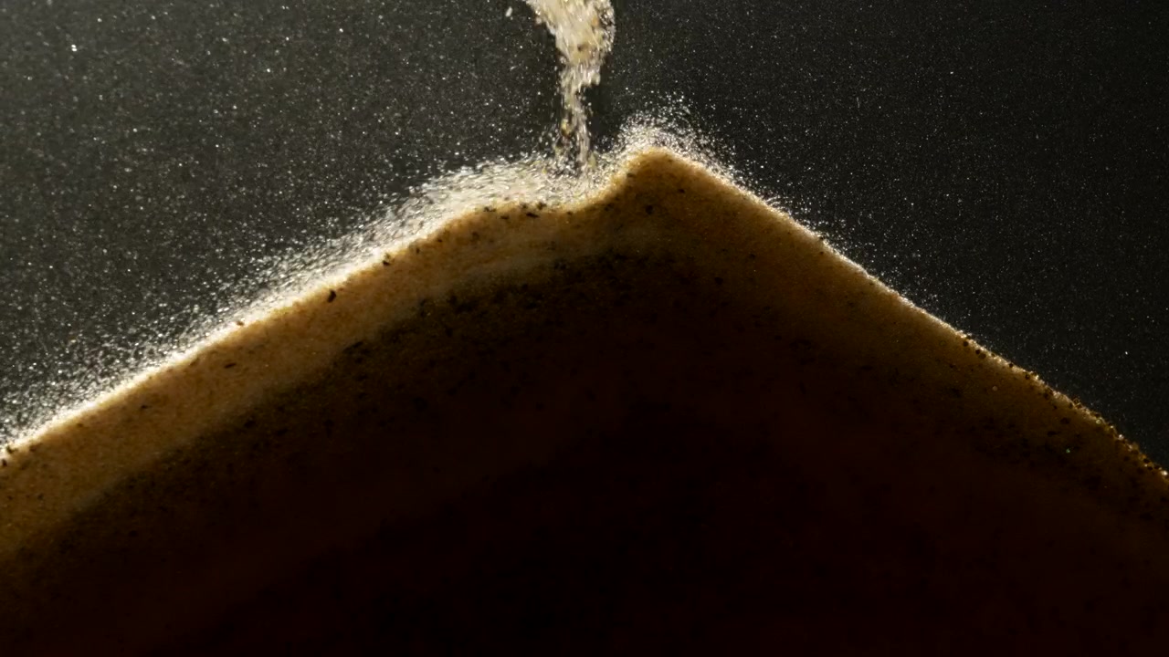 Sand particles falling down in abstract slow motion. Macro shot
