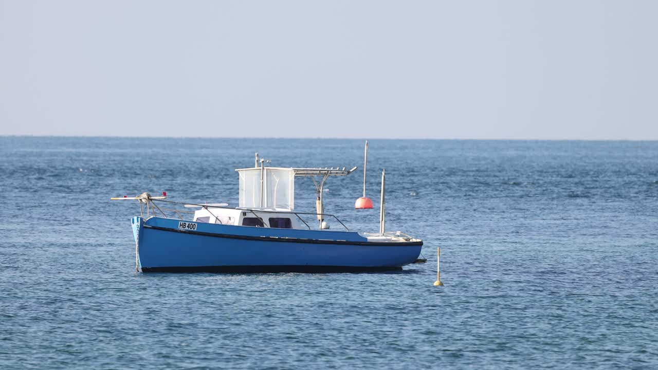 un barco azul anclado cerca de una boya