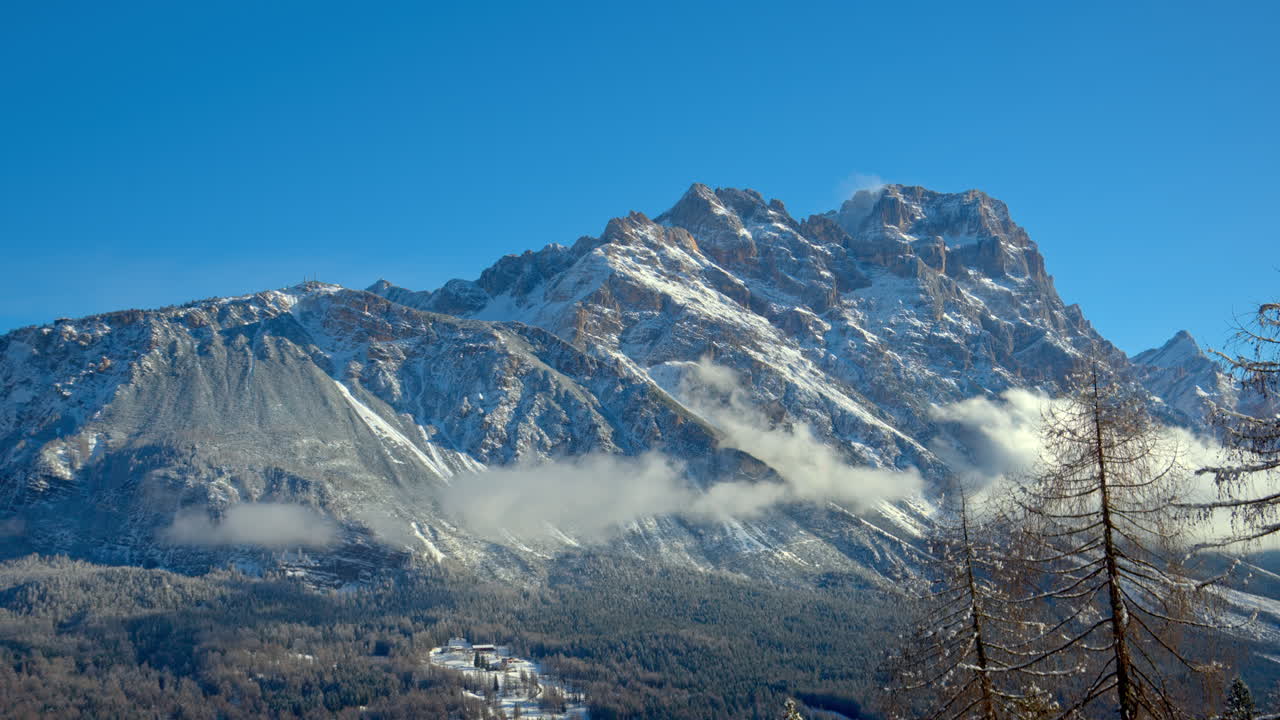 Vista sulla neve sugli alberi e sulle montagne delle Dolomiti, Italia, con il cielo nuvoloso sullo sfondo