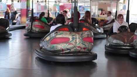 personas disfrutando de coches de parachoques en una feria