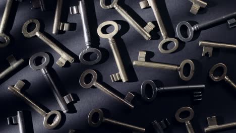 Old keys rotating over black background