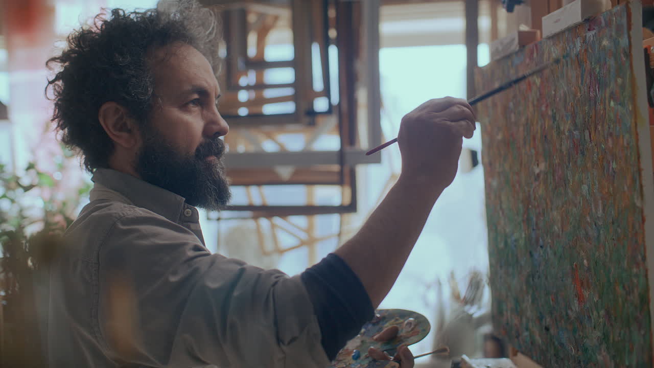 Talented Male Artist Painting Abstract Art on Canvas in Creative Studio