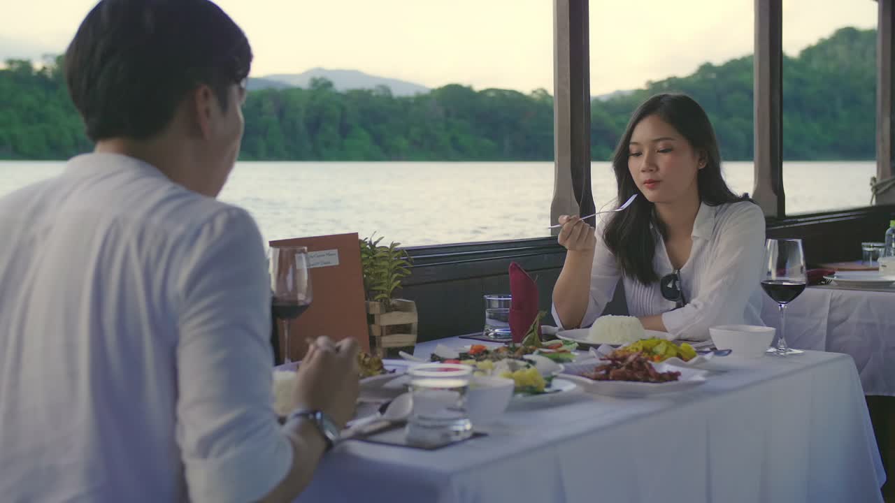 Asian Couple Happy Eating Food On Boat With A Nice View,Slow Motion