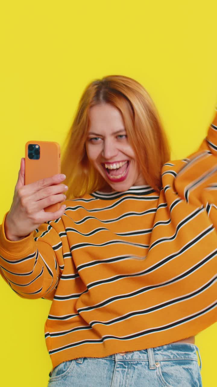 feliz ganador emocionado mujer usar teléfono inteligente celebrar el éxito ganar jugar juego buenas noticias de lotería