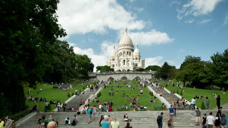 sacre coeur cathedral in paris with tourists on the steps