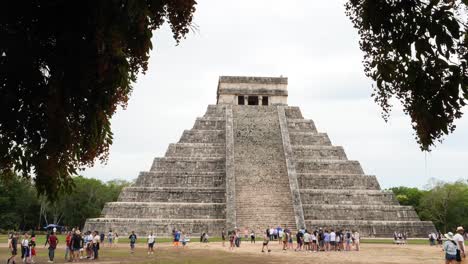 temple of kukulcán (el castillo) at chichen itza. tourists visiting the archeological site.