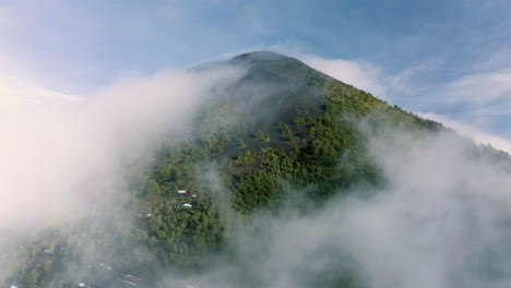 Dolly-Aéreo-Panorámico-Mientras-Las-Nubes-Se-Elevan-A-Lo-Largo-De-Las-Laderas-Volcánicas-Contra-El-Cielo-Azul-En-Guatemala