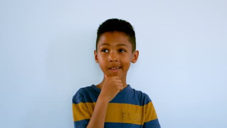 thoughtful african american schoolboy with hand on chin standing against whiteboard 4k