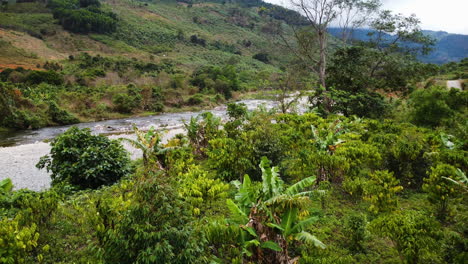 aerial backwards view of a rural area deforested and crossed by a river