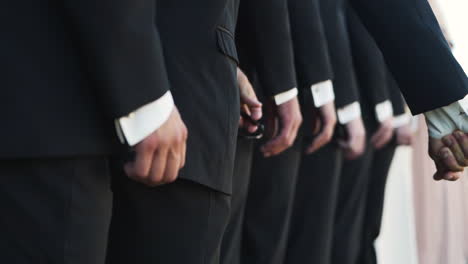 lineup of groomsmen hands during a wedding