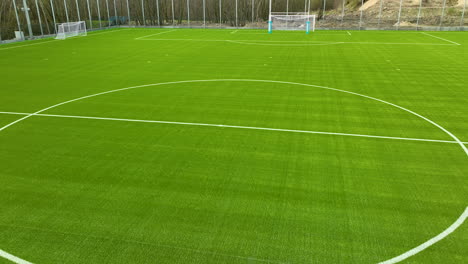 Un-Campo-De-Fútbol-Bien-Mantenido-Con-Césped-Artificial-De-Color-Verde-Brillante-Y-Líneas-Blancas-Que-Marcan-El-Campo