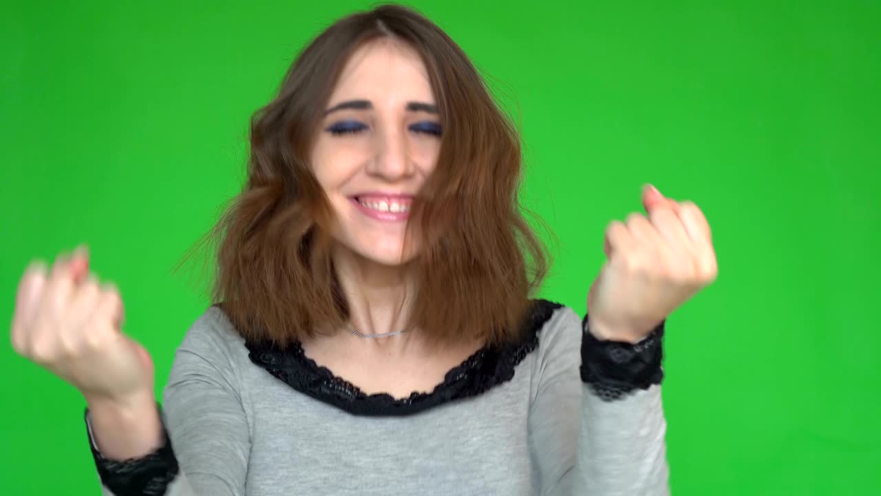 Young woman being excited and glad to achieve victory, exclaiming and smiling.