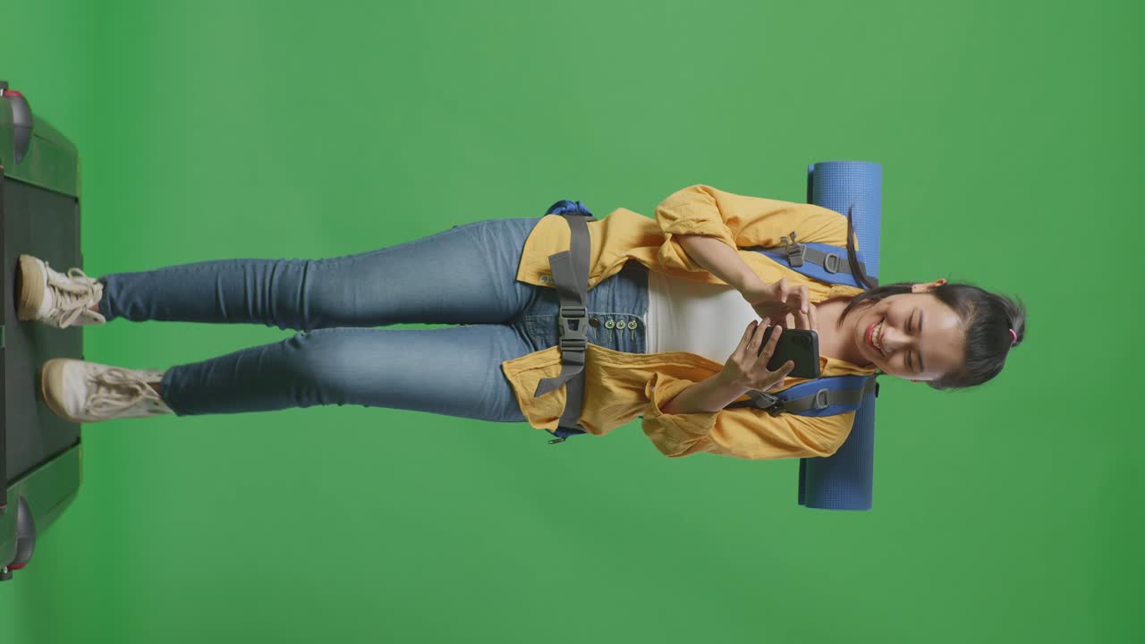 mujer viajera en pantalla verde con mochila y teléfono móvil