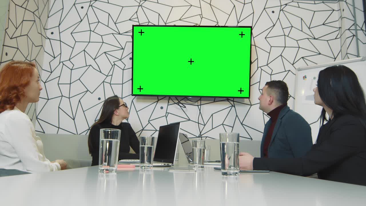 un equipo de personas de negocios en una sala de conferencias viendo una imagen en una pantalla de televisión. muelle de cromo en la pantalla y puntos de trekking. cámara móvil personas de negocios durante una videoconferencia