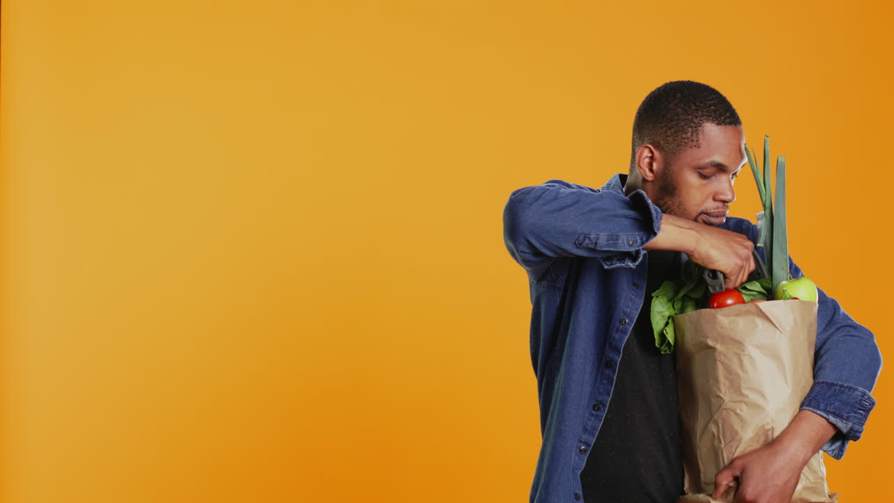 Young person scanning fresh organic produce in a paper bag,