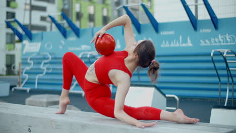 woman performing acrobatics with ball in a city park