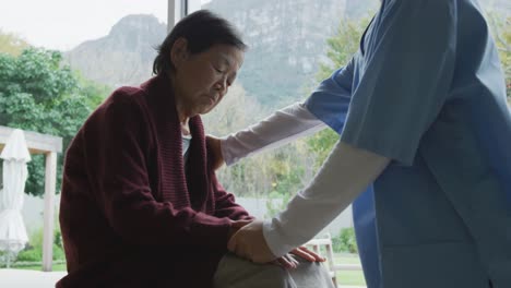 Smiling-asian-female-doctor-comforting-senior-female-patient-and-talking-at-surgery