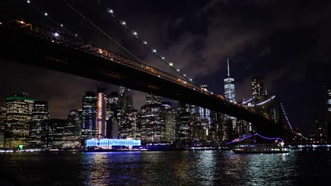 new york skyline at night with brooklyn bridge in foreground