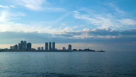 Edificios-De-Gran-Altura-En-La-Ciudad-De-Sokcho-Contra-El-Cielo-Azul-Con-El-Mar-Del-Este-En-Primer-Plano-En-Gangwon,-Corea-Del-Sur