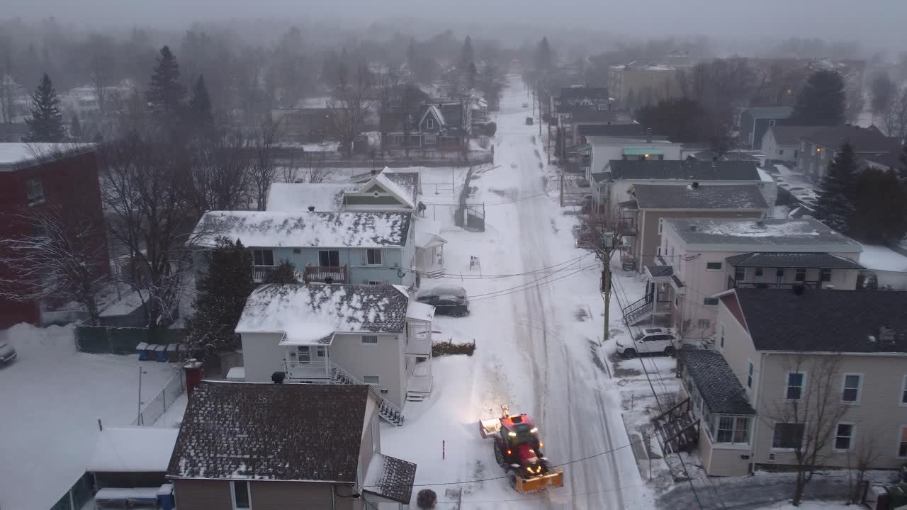 Orford town blanketed in snow on a cold winter day with snow removal vehicle, Quebec, Canada.