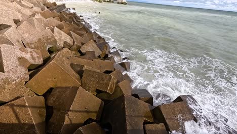 waves hitting concrete blocks on the shoreline