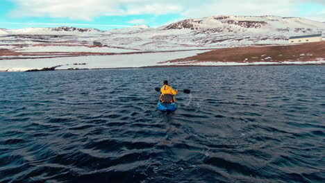 man in yellow jacket trying to get to shore on kayak, wild ocean waves