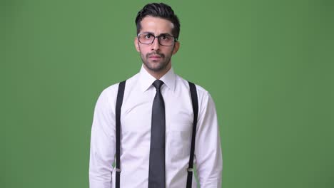 joven empresario persa barbudo y guapo contra un fondo verde