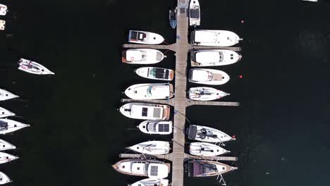 wooden pier walkway and yachts, aerial top down view