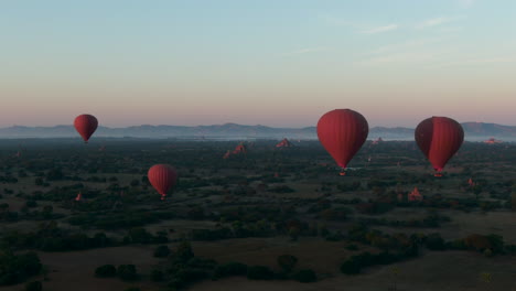 Gruppe-Von-Heißluftballons-über-Den-Ebenen-Von-Bagan,-Myanmar,-Wunderschöne-Filmische-Weitwinkel-Luftaufnahme
