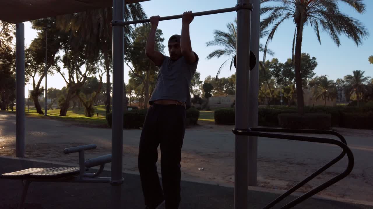 young man doing pull ups on horizontal bar