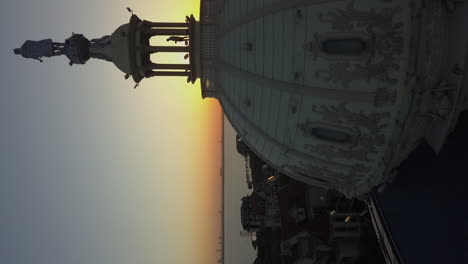 Vertical-format:-Sunset-aerial-flies-past-ornate-dome-atop-building