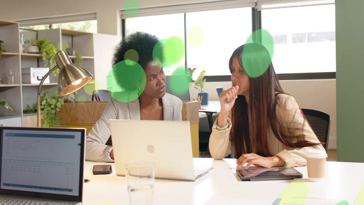 Business colleagues reacting to green overlay, reviewing laptop or tablet and agreeing