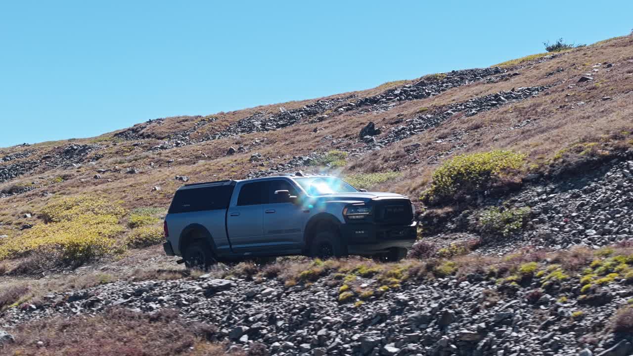 Sideview orbit around truck glistening from sunlight as it drives up along Peak 10 trail Breckenridge Colorado