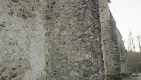 a close-up view of the ancient stone wall of the 14th century gothic church in velhartice with its rough and weathered structure