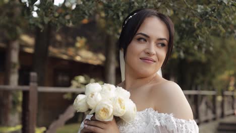 hermosa novia en un vestido blanco con un ramo de flores