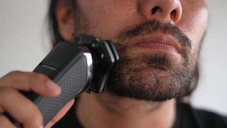 Hombre-Latino-Recortando-Barba-Y-Bigote-Con-Maquinilla-De-Afeitar-Eléctrica,-Cortapelos