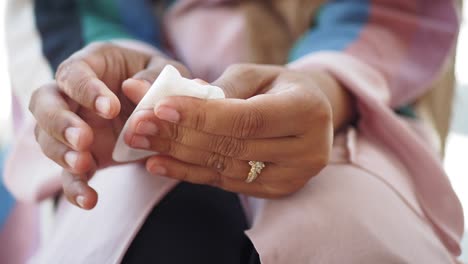 woman with ring on finger holding tissue