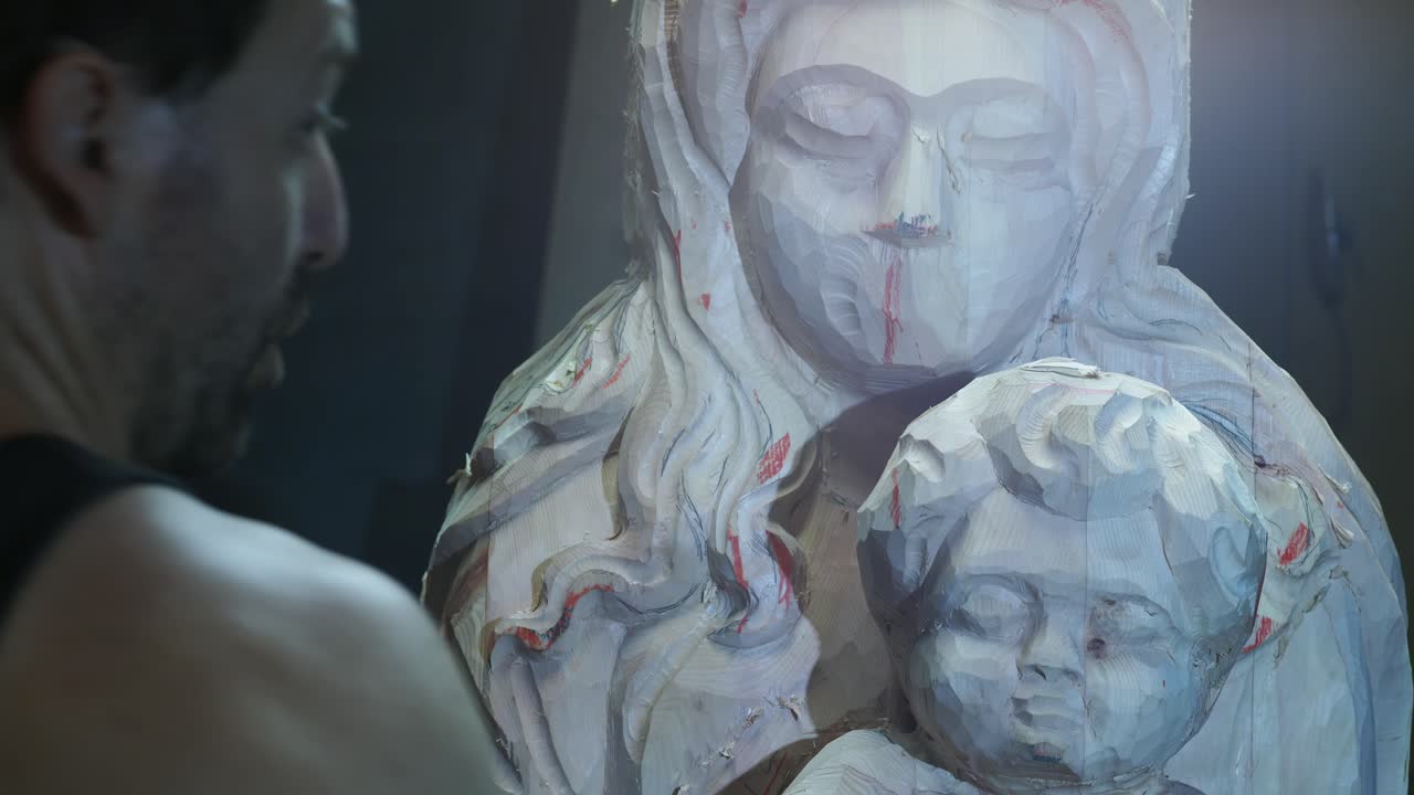 Professional sculptor carving delicate wooden statue with traditional chisel, showcasing meticulous craftsmanship inside well-organized workshop studio