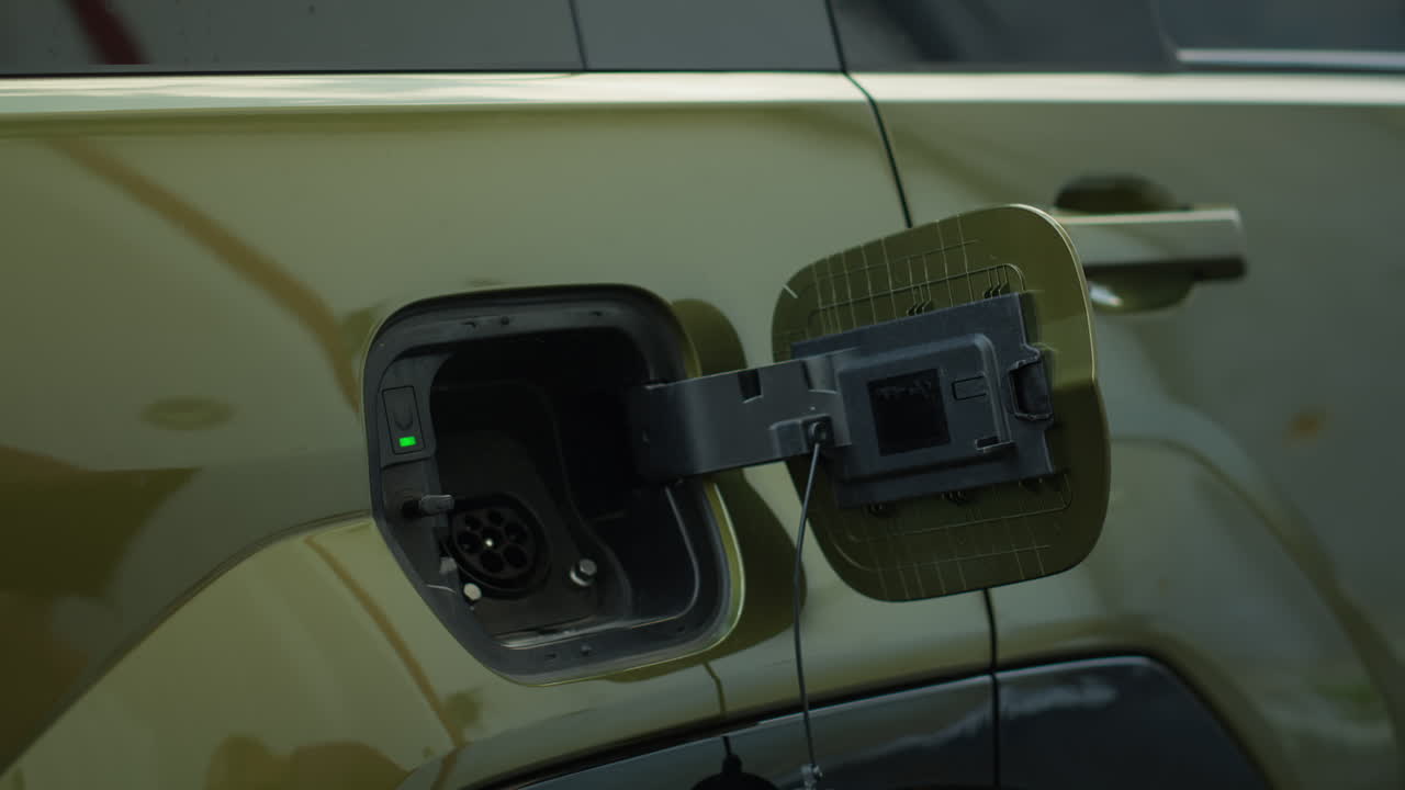 Close Up Of Driver Connecting Ev Plug To Electric Car To Recharge It