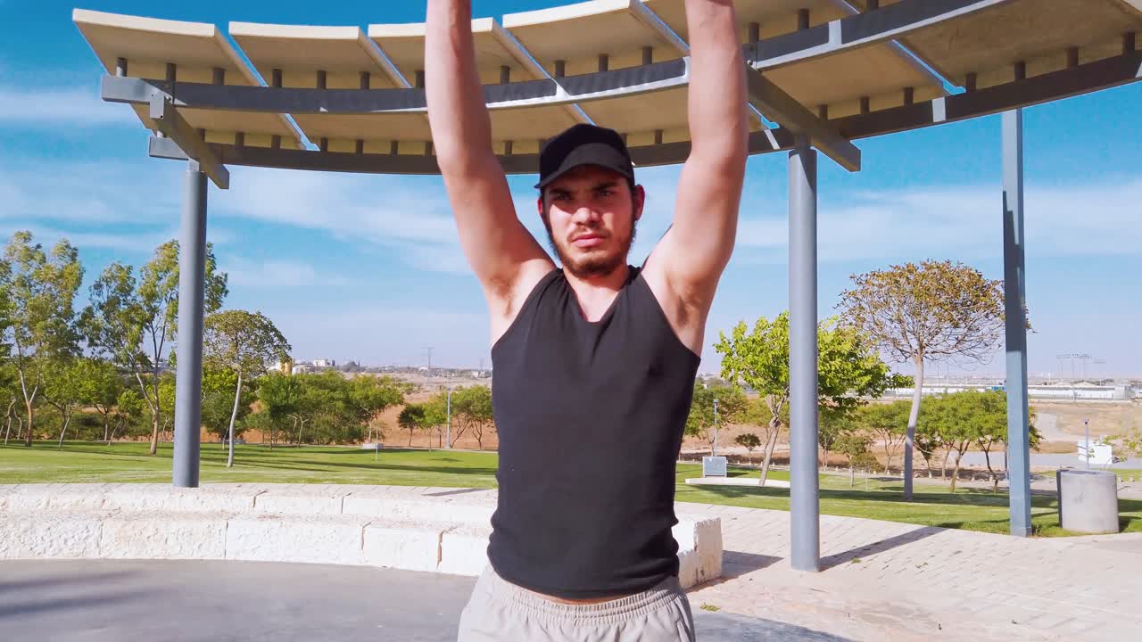 Man in a park with arms raised